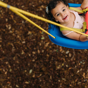 Girl looks up at camera while swinging