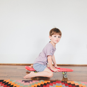Boy on skateboard plays in living room