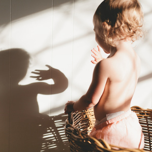 Little girl waves at her shadow