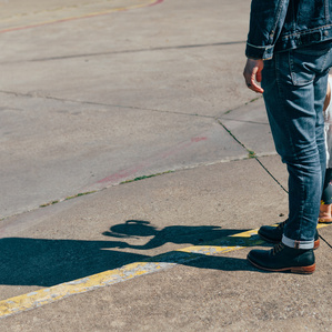 Father and daughter stand next to each other looking at shadows