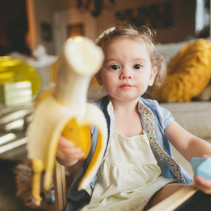 Girl with banana point at camera
