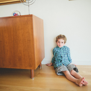 Boy sits on floor of living room