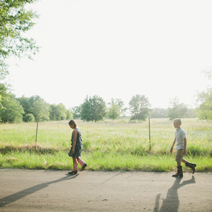 Three sibling walk along a country road in evening sunlight