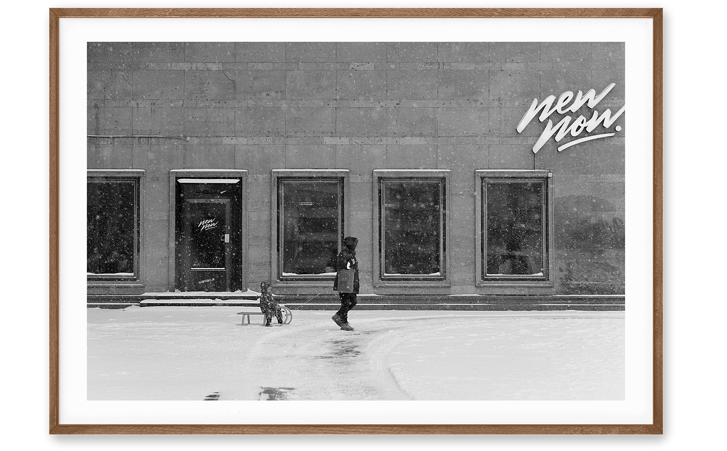An analog image of a woman draging a sledge with her son through the snow in Berlin.