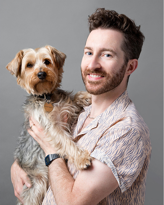 Jonny the London Dog Photographer, Woof Photography, and Pico his Yorkshire terrier.  Photo taken in his East London studio and features a grey backdrop. 