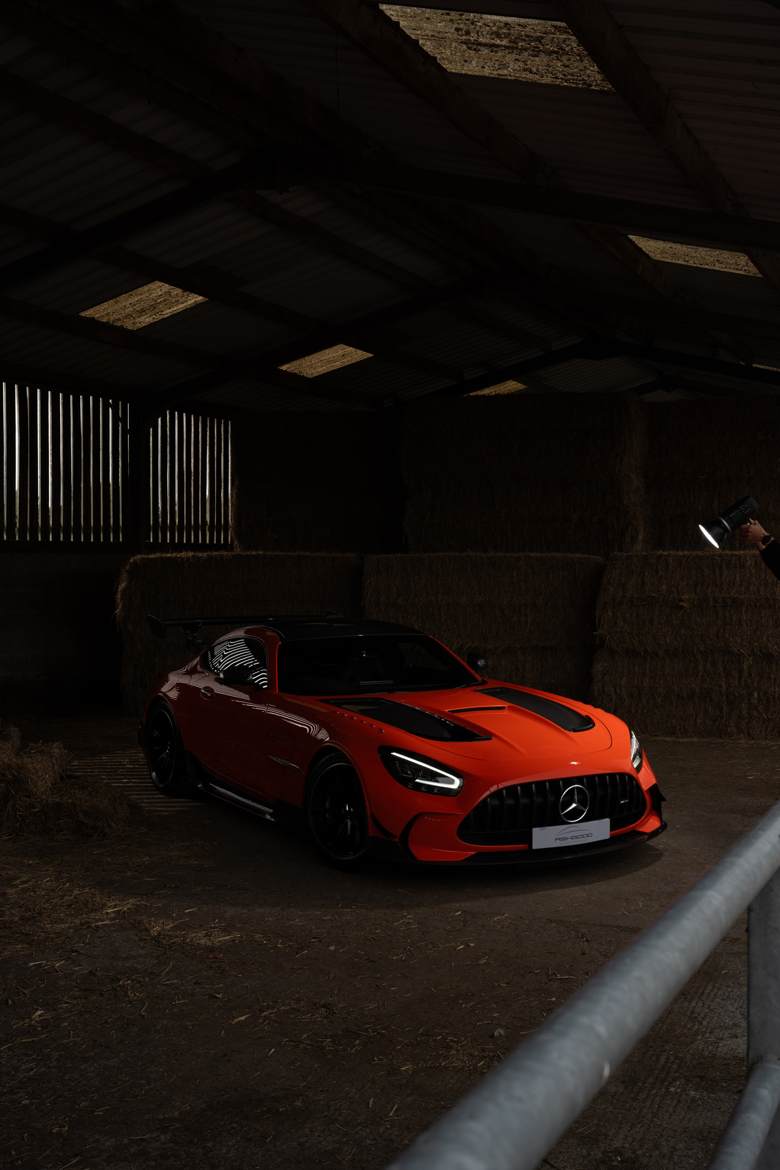 Orange Mercedes AMG GTR Black Edition photographed using flash in a dark farm barn