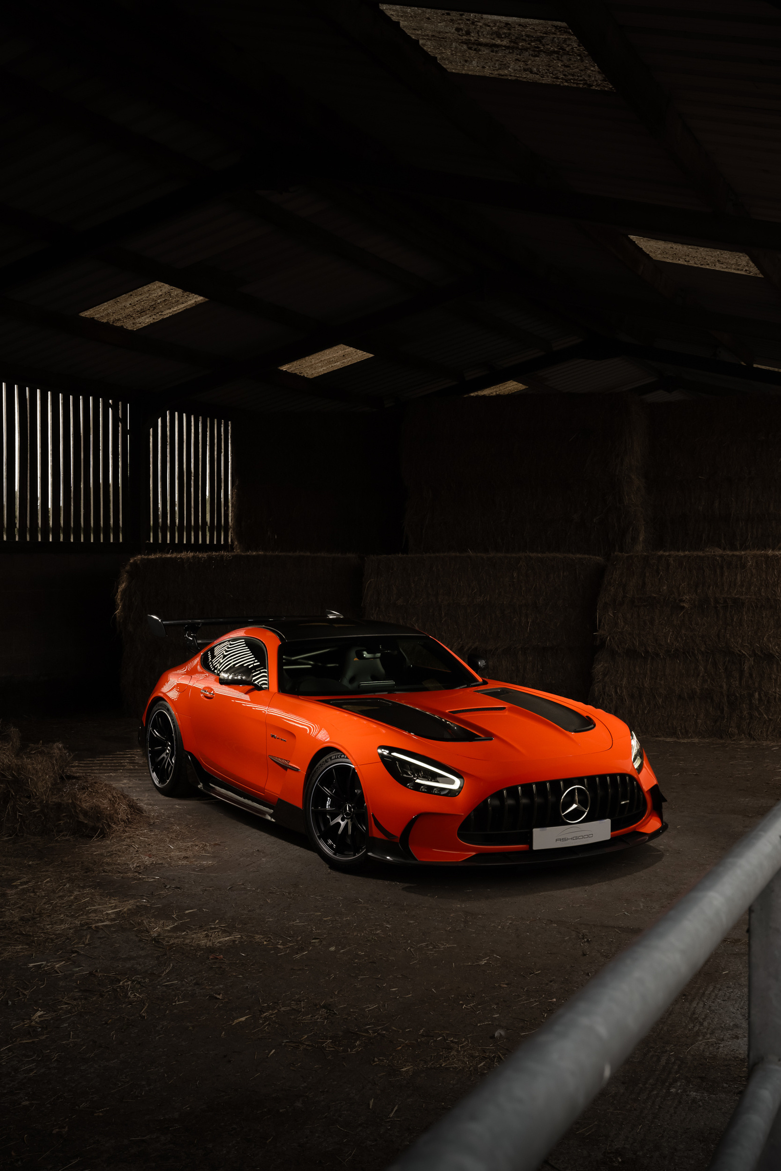 Orange Mercedes AMG GTR Black Edition photographed using flash in a dark farm barn
