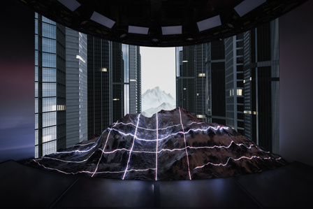 model snowy mountain lit up by lasers in front of a video screen 