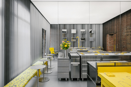 refurbished steel kitchen appliances in a metal colored store with touches of yellow.