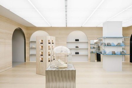 travertine wall arches with metal shelves and white box ceiling surrounding various custom pieces of furniture