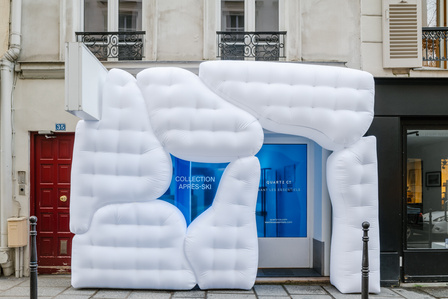 white inflatable structure in front of a store with blue windows.