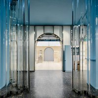 wavy glass, store entrance, black terrazzo, blue pillars, 