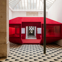 red velvet structure set inside a typical Parisian art gallery interior.