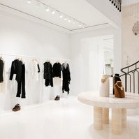 Stone table display set in a white clothing store near a staircase
