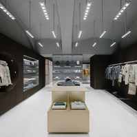 brass piece of furniture set in a clothing store, burnt cork walls and custom lighting