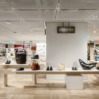 pop-up store showing various leather items displayed on a solid ash wood module inside a retail space.