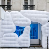 white inflatable structure in front of showroom blue-tint window.
