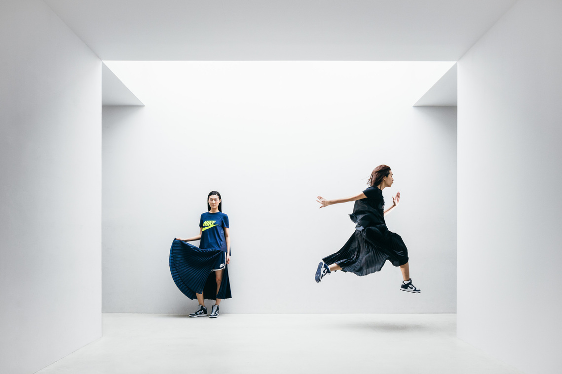 asian models, movement, jumping, blue dress, black dress, sneakers, symmetry, architecture, white walls, fashion