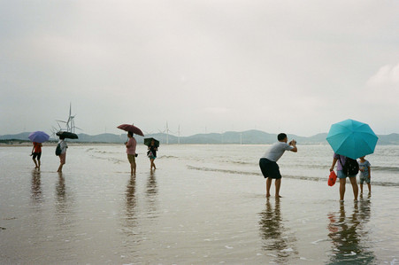 windmills, beach, waves, sand, people, feet in water, umbrellas, china, pingtan