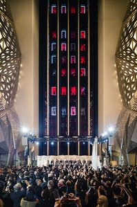morpheus hotel elevators lit in red light while an orchestra is playing for a crowd