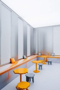 pixelated metal wallpaper with low-resolution orange tables and stools.