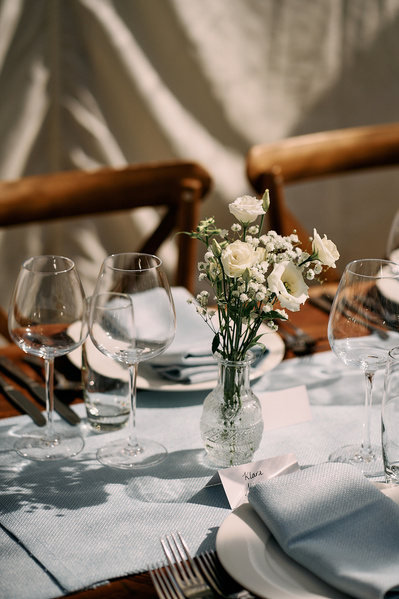 A table setting in a restaurant being illuminated by streaks of light of the soft evening sun. 