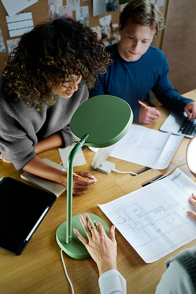 Three architects sit around a desk. 