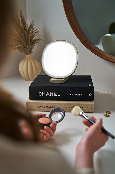 A detail product shot of a Lumie lamp on some books. 