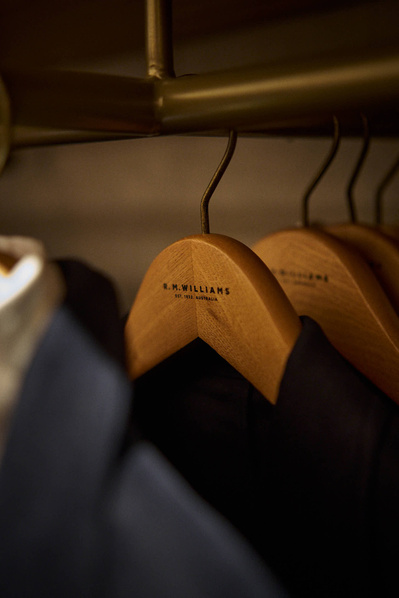A close up shot of a suit jacket hanging on a rail in a menswear shop. 