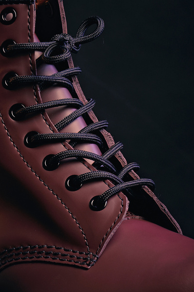 stylish and cinematic close up product shot of a Dr Martens 1460 red boot, focussing on the laces. 