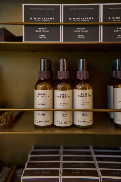 leather care products on a shelf in a menswear shop