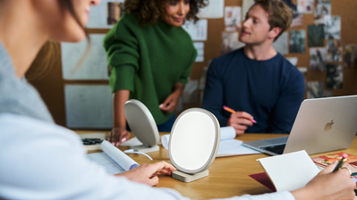 Three architects working in an office around a Lumie lamp. 