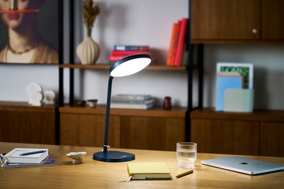 A home office, illuminated by a tall lamp.