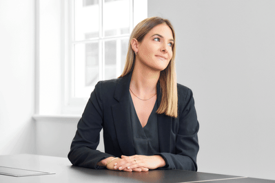 A GIF of a woman in a corporate portrait laughing
