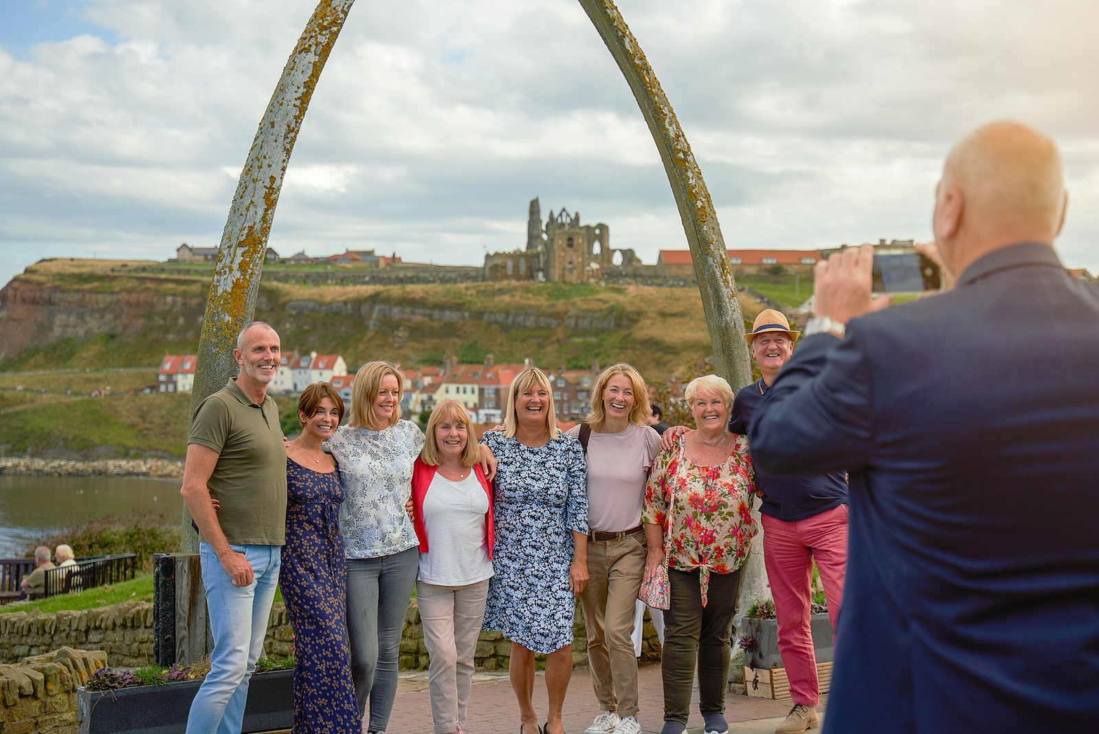 a group of people taking a photo in front of an arch
