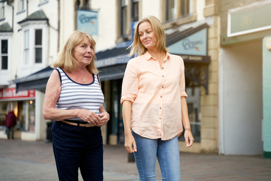 two people walking through the street