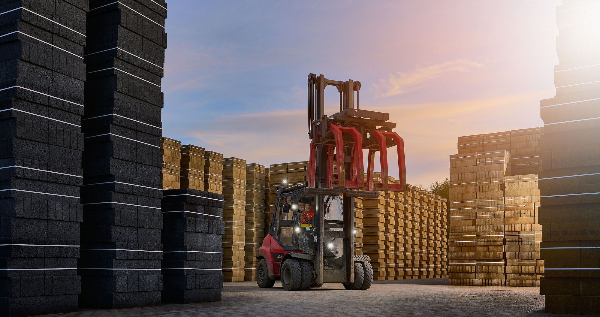 A cinematic evening portrait of a red fork lift and driver sitting amongst tall piles of brick and slate, illuminated by the blue and pink sky. 