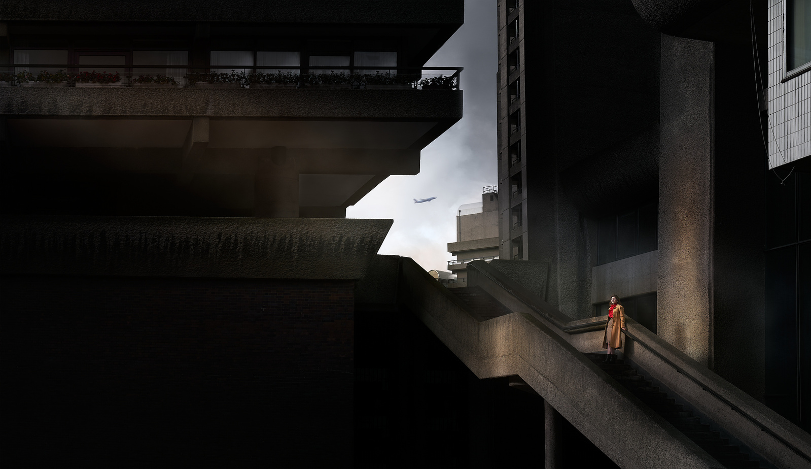 a woman is walking down the stairs in front of a brutalist architecture building. 
