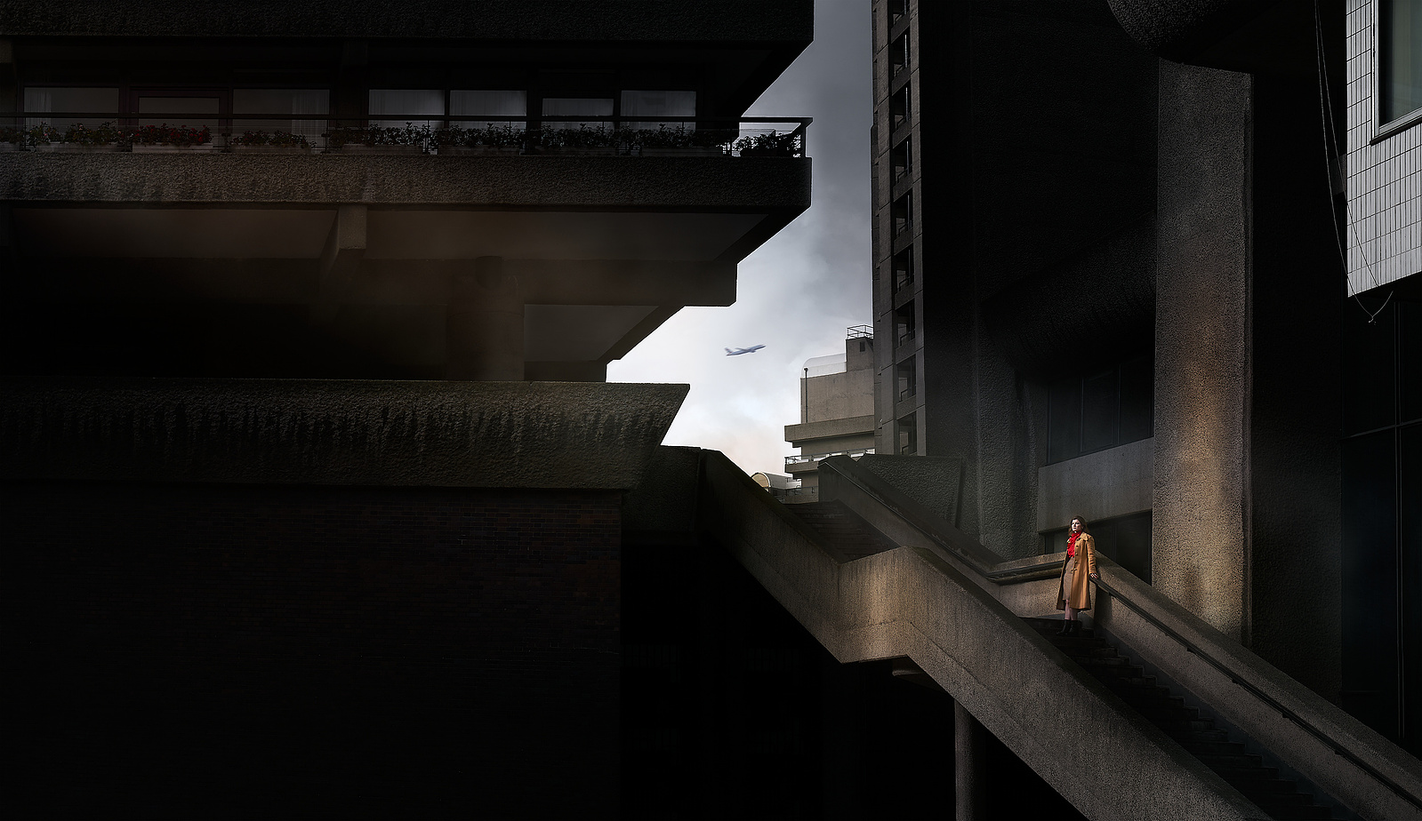 a woman is walking down the stairs in front of a brutalist architecture building. 