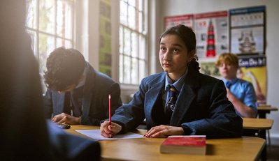 A school girl in class looking upwards