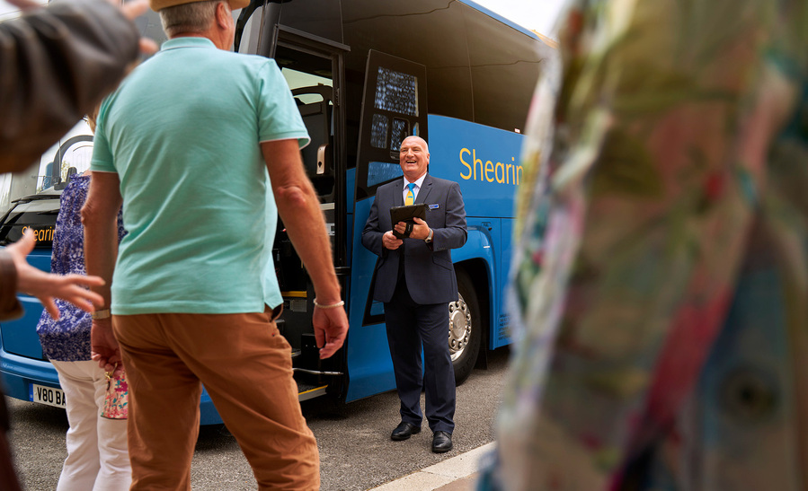 a group of people standing in front of a blue bus