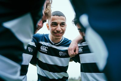 A tight photograph of a huddle of young rugby players