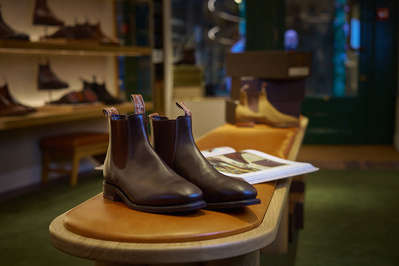 A close up shot of a pair of brown leather boots in a menswear shop. 