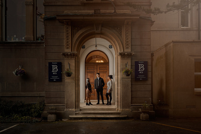 Three students stand in a school archway