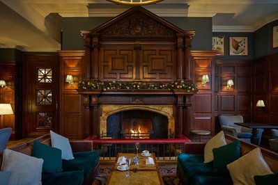A roaring fire place in a hotel library. 