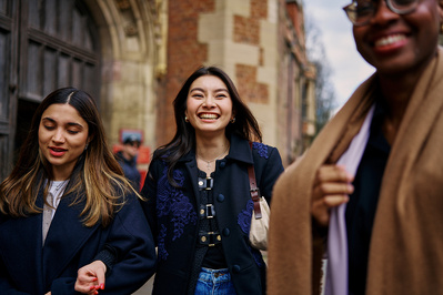 three happy asian university students walking hand in hand. 