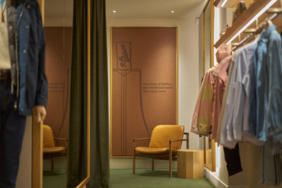 An interior photograph of a mens shoe shop seating area. 