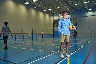 Boy holding a ball in a school gym