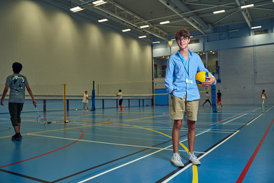 Boy holding a ball in a school gym