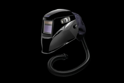 A black welders helmet photographed on a black background. 
